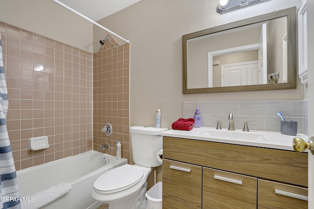 bathroom with tasteful backsplash, a textured wall, toilet, shower / bath combo with shower curtain, and vanity