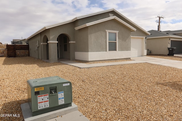 ranch-style home featuring driveway, a garage, and stucco siding