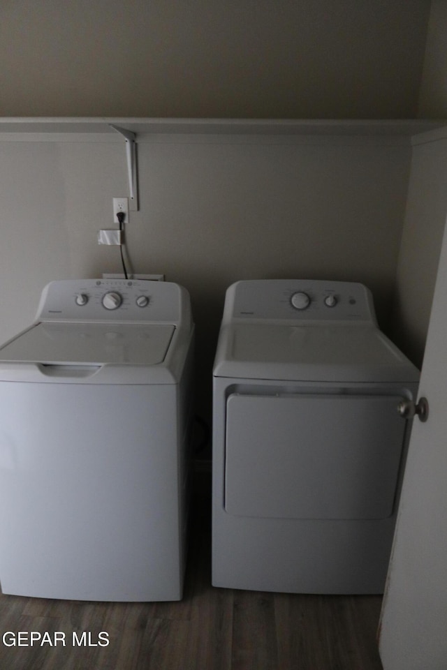 laundry room with laundry area, washing machine and dryer, and wood finished floors