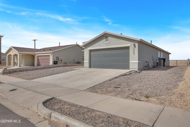 ranch-style home with driveway, an attached garage, and stucco siding