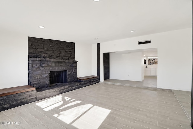 unfurnished living room featuring recessed lighting, a fireplace, visible vents, and wood finish floors