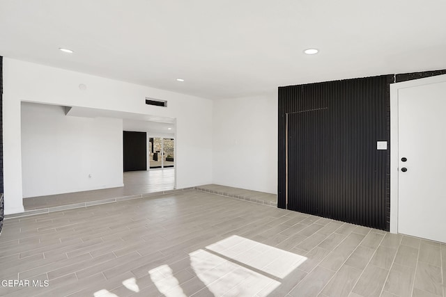 unfurnished room featuring visible vents, wood finish floors, and recessed lighting