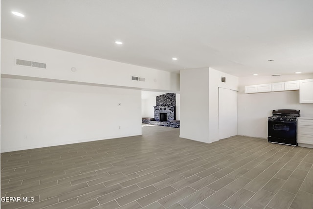 unfurnished living room featuring a fireplace, visible vents, and recessed lighting