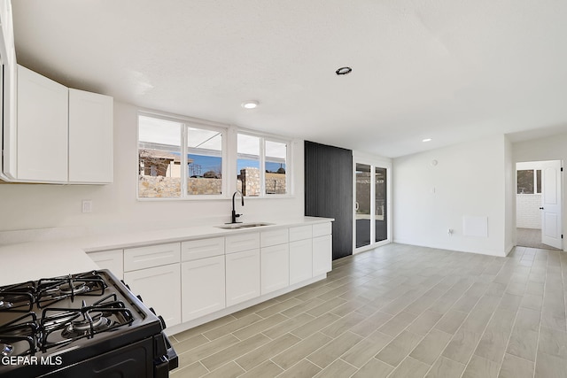 kitchen with light countertops, a sink, and white cabinetry