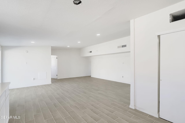 interior space featuring light wood-type flooring, visible vents, and recessed lighting