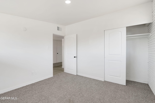 unfurnished bedroom featuring carpet floors, baseboards, visible vents, and a closet