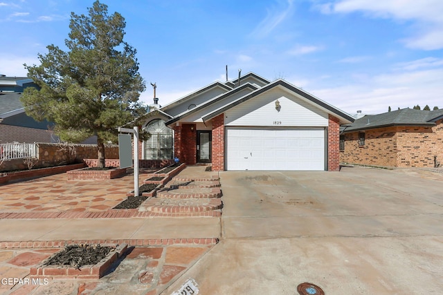 ranch-style house with a garage, brick siding, concrete driveway, and fence