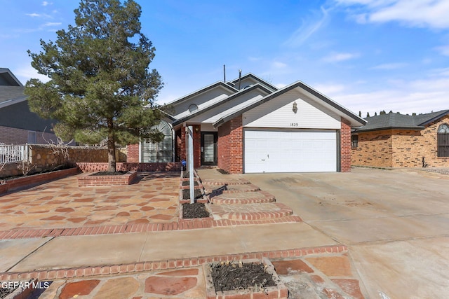 ranch-style house featuring brick siding, an attached garage, driveway, and fence