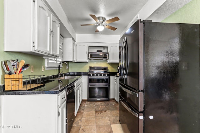 kitchen featuring a sink, dark countertops, freestanding refrigerator, range with two ovens, and dishwashing machine