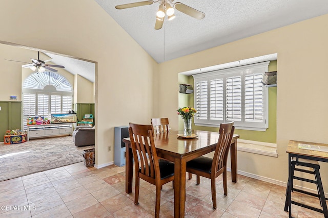 carpeted dining area with tile patterned floors, lofted ceiling, a textured ceiling, baseboards, and ceiling fan