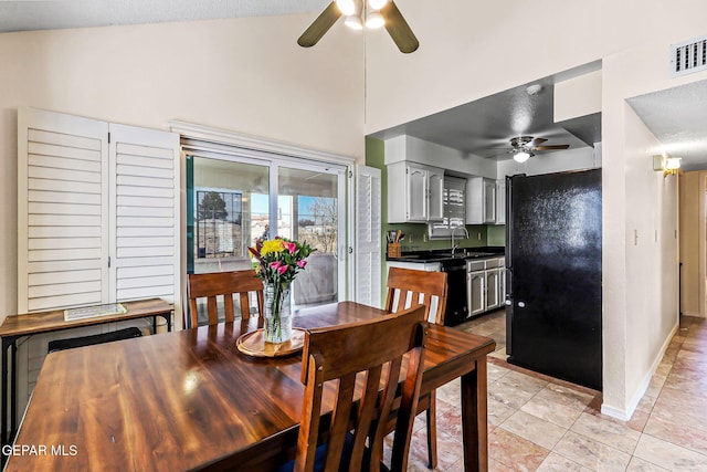 dining area featuring visible vents, high vaulted ceiling, a ceiling fan, light tile patterned flooring, and baseboards