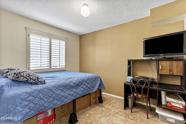 bedroom with baseboards and a textured ceiling