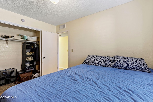 bedroom featuring visible vents, a closet, and a textured ceiling