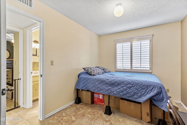 bedroom with visible vents, a textured ceiling, and baseboards