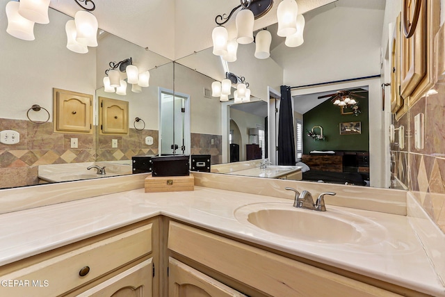 full bathroom featuring decorative backsplash, a sink, ceiling fan, and double vanity