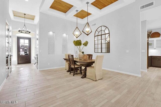 dining space with visible vents, baseboards, coffered ceiling, and light wood-style flooring