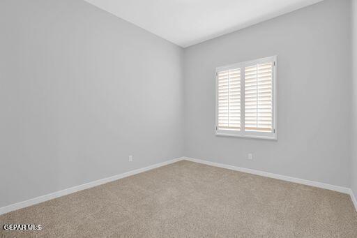 carpeted empty room with baseboards