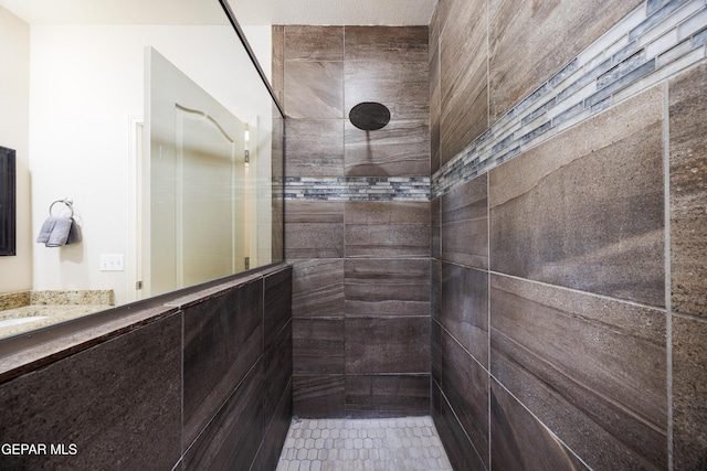 bathroom with vanity and tiled shower