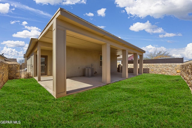 rear view of house with a yard, a patio area, fence, and stucco siding