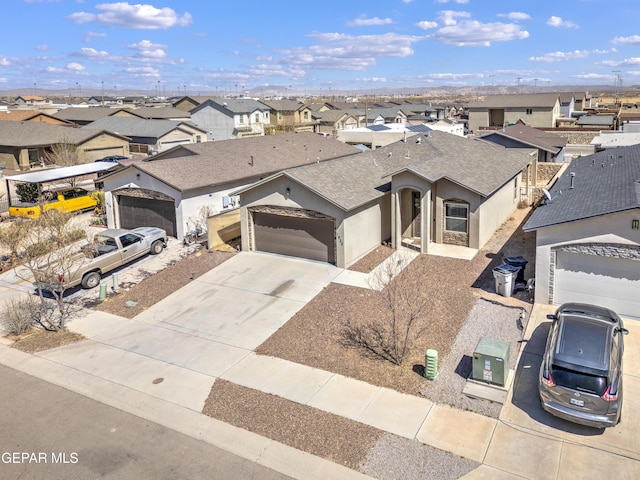 view of front of house with a shingled roof, stucco siding, concrete driveway, a garage, and a residential view