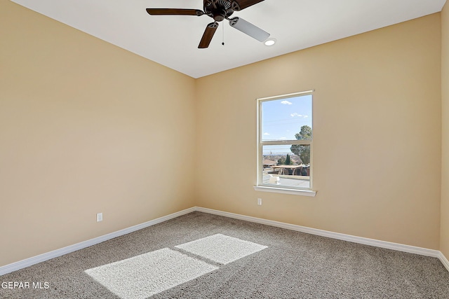 spare room featuring ceiling fan, carpet floors, and baseboards