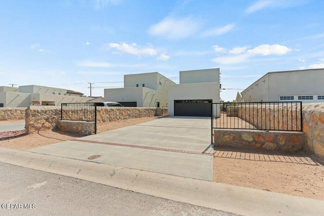 view of front of house with concrete driveway, a gate, a fenced front yard, and stucco siding