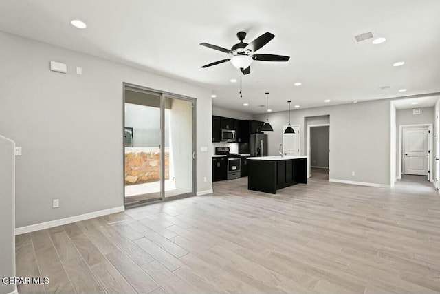 unfurnished living room featuring recessed lighting, baseboards, ceiling fan, and light wood finished floors