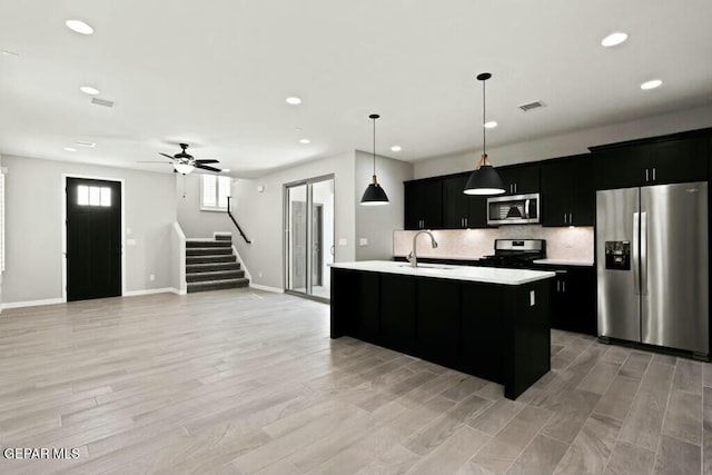 kitchen featuring visible vents, backsplash, light countertops, appliances with stainless steel finishes, and dark cabinets