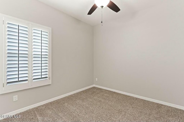 carpeted spare room featuring baseboards and ceiling fan