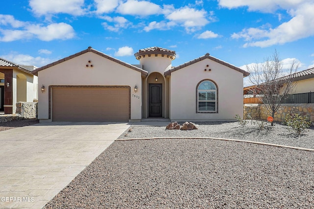 mediterranean / spanish-style home with a garage, fence, a tile roof, driveway, and stucco siding