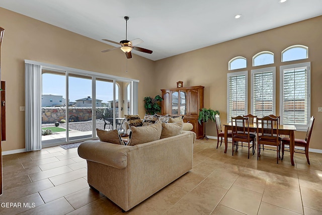 living room with light tile patterned floors, recessed lighting, a towering ceiling, a ceiling fan, and baseboards