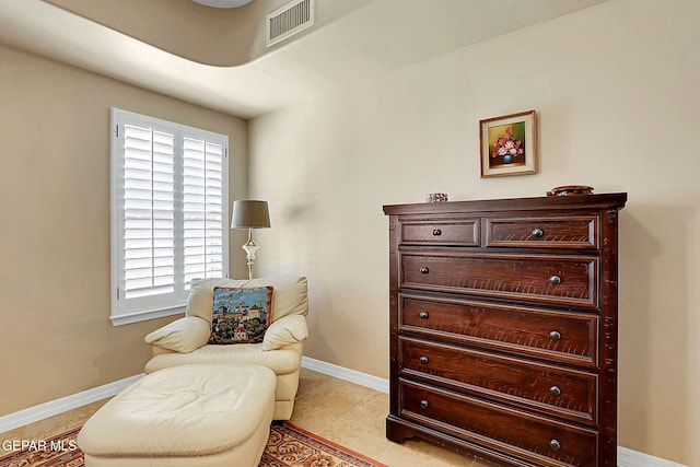 living area with visible vents, baseboards, and light tile patterned floors