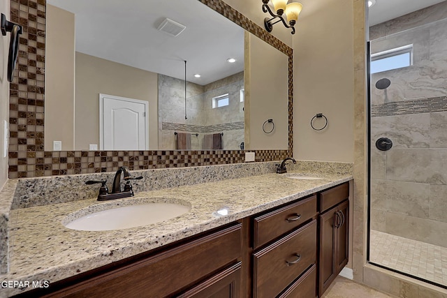 full bathroom featuring double vanity, visible vents, walk in shower, and a sink