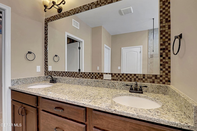 bathroom featuring double vanity, a sink, and visible vents