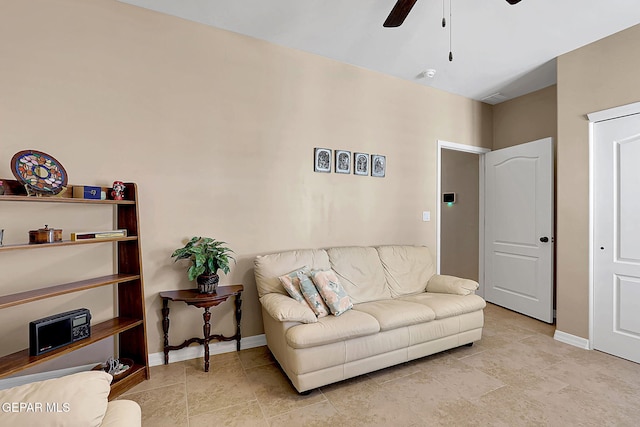 living area with ceiling fan and baseboards