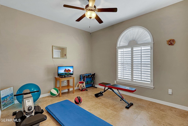 workout room featuring a ceiling fan, baseboards, and tile patterned floors