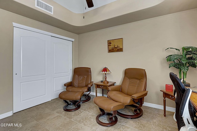 sitting room with a ceiling fan, visible vents, and baseboards