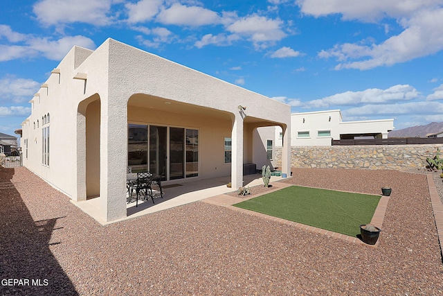 back of house with a patio, a fenced backyard, and stucco siding