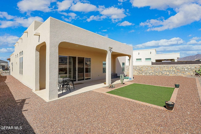 rear view of house with a patio area and stucco siding