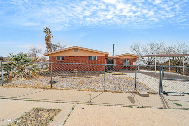 view of front of house with a fenced front yard, a gate, and brick siding