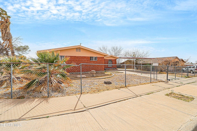 view of front facade featuring a fenced front yard, a gate, and brick siding