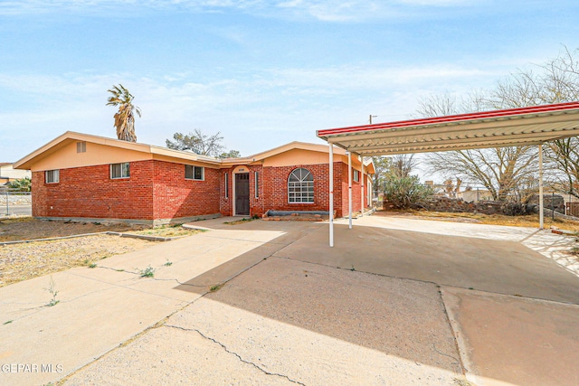 single story home with driveway, an attached carport, and brick siding