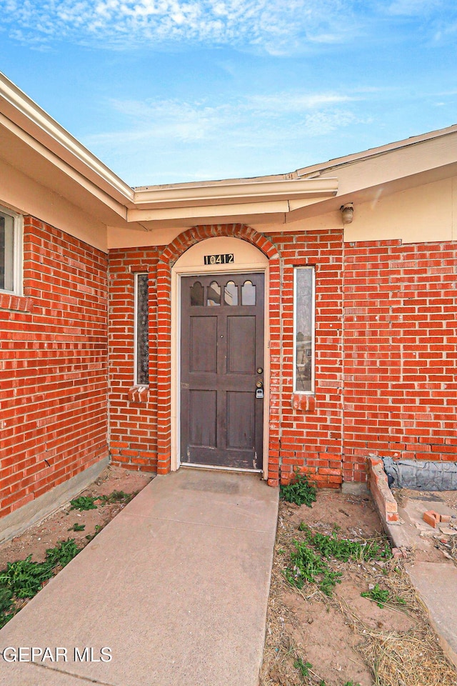 entrance to property featuring brick siding