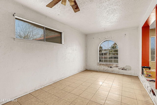 tiled spare room with ceiling fan and a textured ceiling