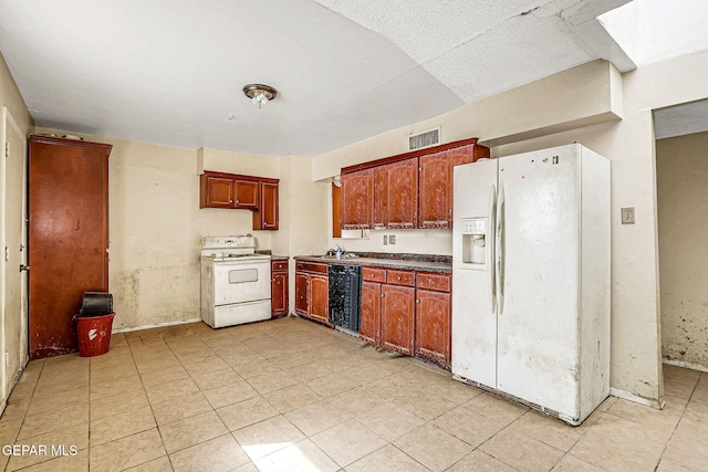 kitchen featuring dark countertops, white appliances, visible vents, and a sink