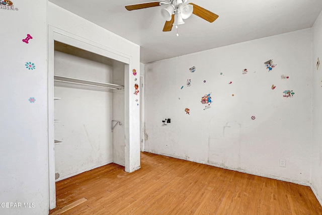 unfurnished bedroom featuring light wood finished floors, ceiling fan, and a closet