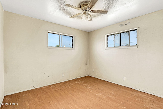 empty room with a ceiling fan and wood finished floors