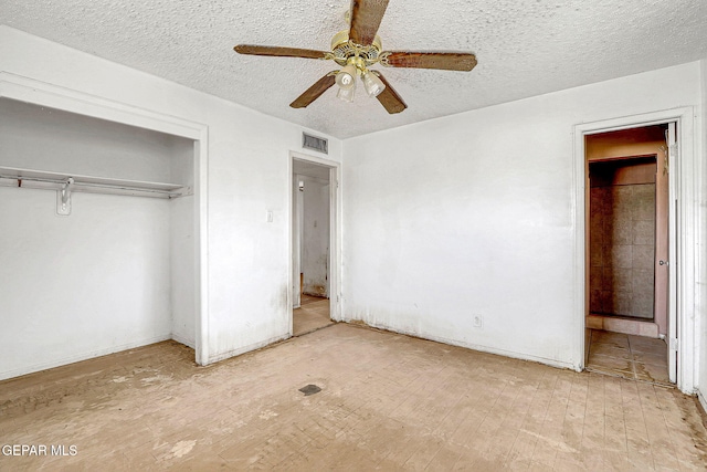 unfurnished bedroom featuring a ceiling fan, a textured ceiling, visible vents, and a closet