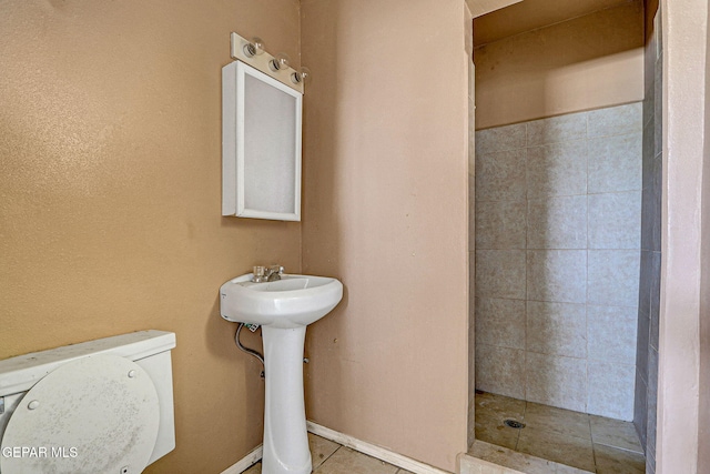 full bath featuring a tile shower and toilet