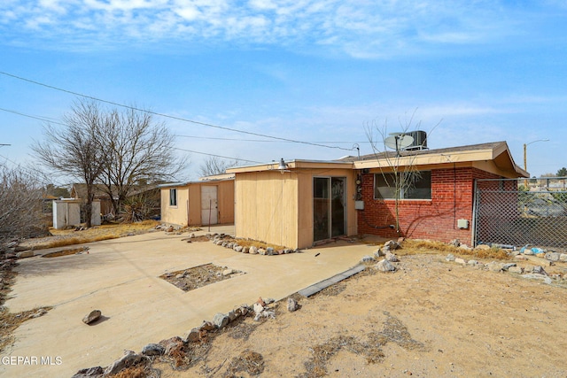 back of house featuring fence, a patio, and brick siding